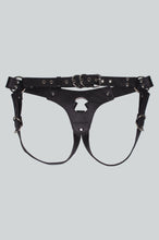 Load image into Gallery viewer, Back of a black leather strap-on harness with silver metal hardware and buckles, photographed flat against a light gray background.