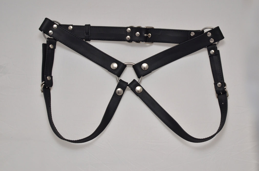 This image features the  Anam Strap-on Harness in genuine leather. The harness is displayed in black, constructed with high-grade materials that are soft on the skin, and includes adjustable straps with snap eyelets and metal buckles for secure fastening.