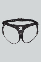 Load image into Gallery viewer, Front of a Black leather STRAP-ON harness with silver-tone metal studs, rings, and hardware, shown flat against a light gray background.