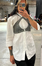 Load image into Gallery viewer, Person wearing a white shirt with a black studded crop top in a mirror selfie.