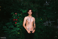 Load image into Gallery viewer, model is standing putside on a green wall of plants, wearing pants and the dalia chain collar
